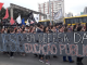 Manifestantes carregam um cartaz escrito 'UFSC em defesa da educação".