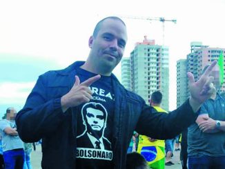 Foto do Deputado Jessé Lopes em evento em Florianópolis fazendo o sinal de armas de Bolsonaro com as mãos