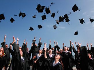 foto de estoque que mostra estudantes se formando arremessando capelos ao ar.