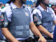Na foto, dois policiais um ao lado do outro com colete à prova de balas e capacete. A fotografia corta a imagem do rosto dos policiais.