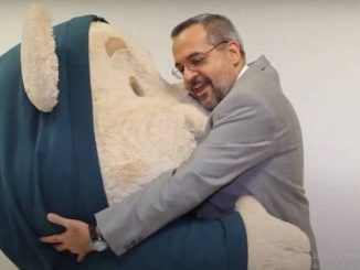 Weintraub abraçando um boneco. Reprodução